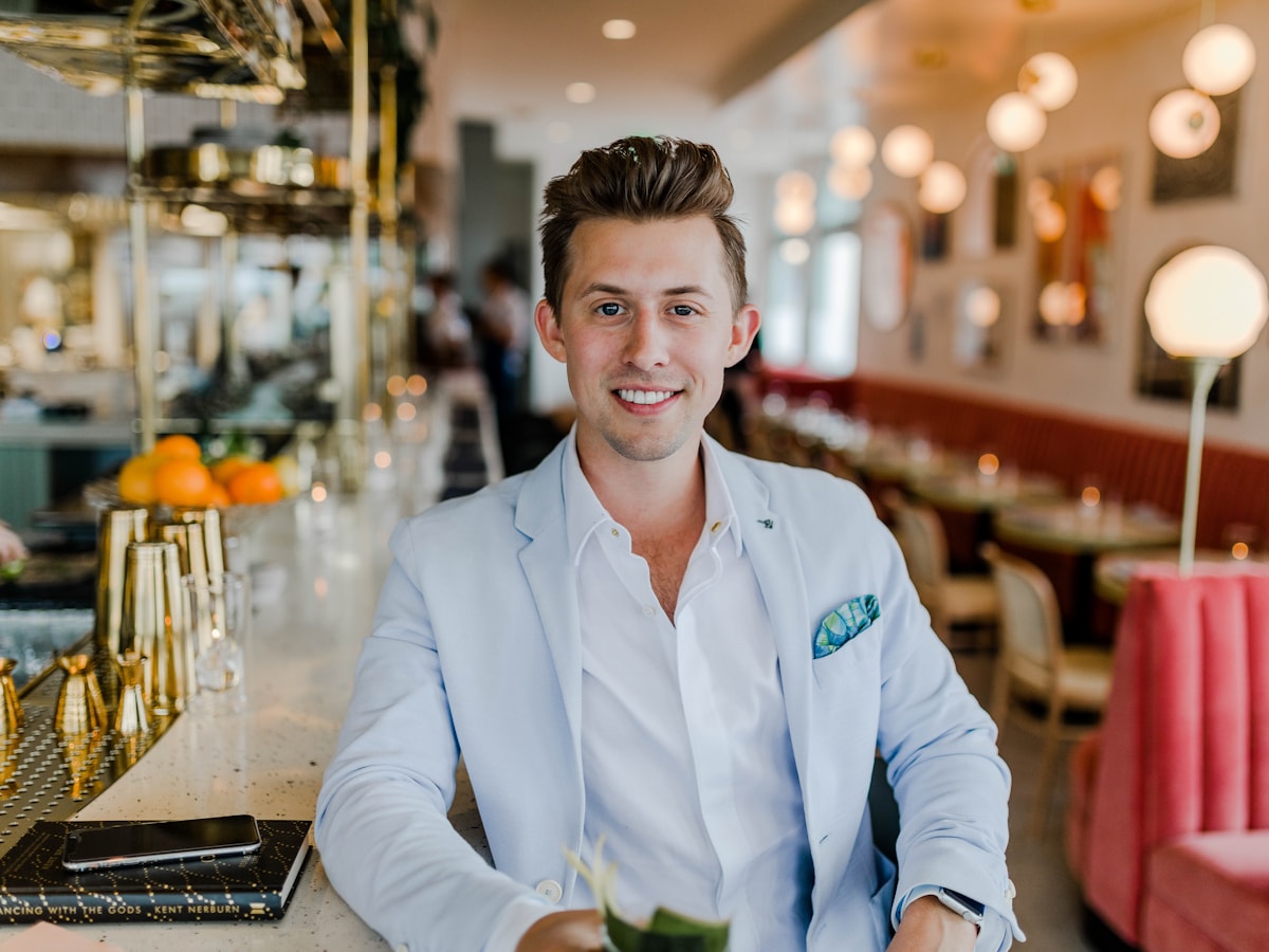 A hospitality business owner seated in a warm restaurant space
